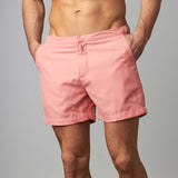 Man wearing tailored swim shorts European style in sand/coral colour