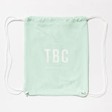 TBC boardshort bag in mint green with white logo, perfect for stylish beach and swim essentials.